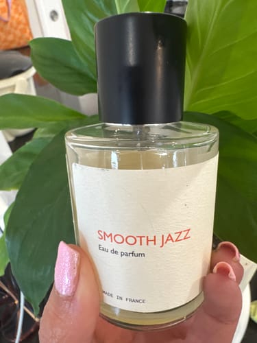 Customer holding their bottle of Smooth Jazz perfume, showing the white label and black cap.