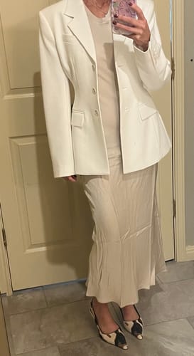 Reviewer wearing the Light Beige Sabrina Sleeveless Satin Dress styled with a long white blazer.