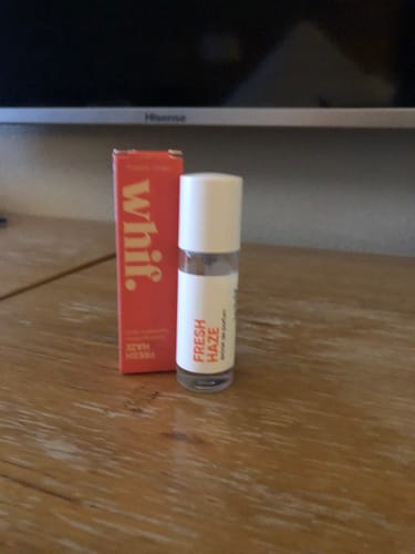 Reviewer's Whif Fresh Haze perfume bottle with its red packaging box on a wooden table.