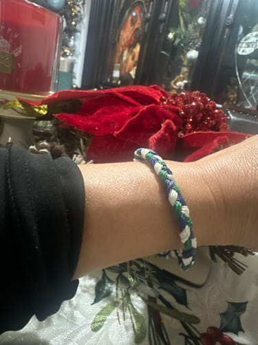 Reviewer's wrist wearing the woven blue, green, and white DAVID Bracelet.