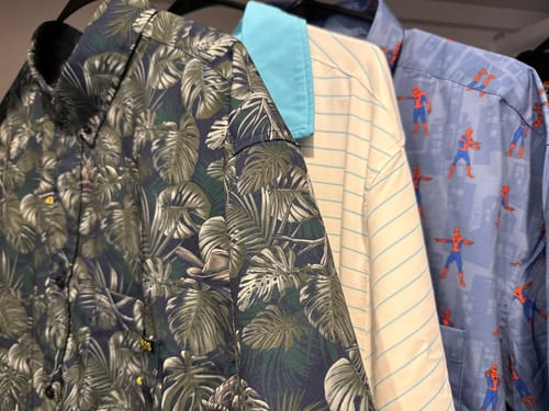 Customer's dark Jurassic Park 'Clever Girl' shirt hanging with other patterned shirts from their collection.