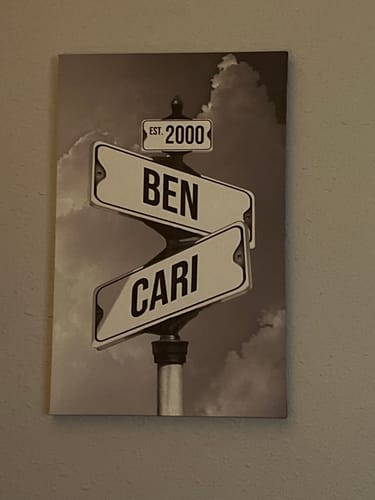 Customer's black and white personalized canvas showing street signs with the names 'Ben' and 'Cari' and 'Est. 2000'.