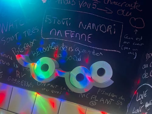 Photo d'un client montrant des rouleaux Popee dans un support mural original, éclairés par des lumières colorées.