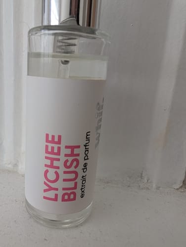A customer's photo of the Lychee Blush perfume bottle, showing its simple white label with pink text.