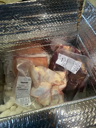 Customer shows various vacuum-sealed meats inside the insulated shipping box, demonstrating the package protection.