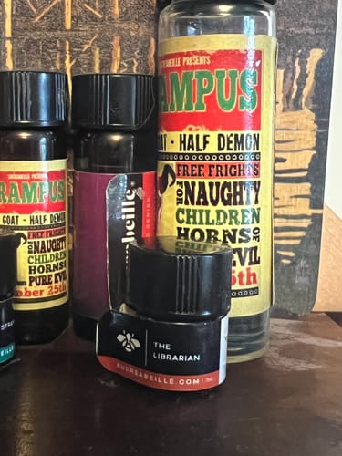 Customer's Krampus perfume bottle shown with The Librarian bottle, which are layered in the review.