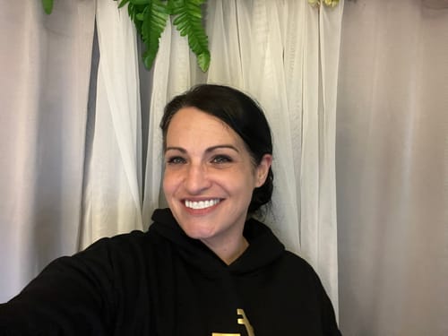 Reviewer with a big, happy smile showing her beautiful results from wearing Pop On Veneers.