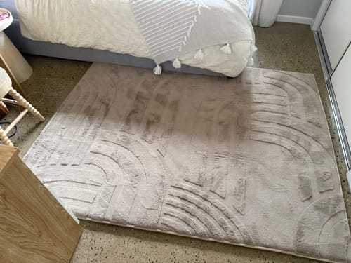 Customer's soft Mellow Mat with a carved geometric design, placed on the floor in a bedroom.