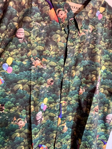 Close-up of the reviewer's Disney and Pixar Up shirt, showing the detailed jungle pattern with characters Carl, Russell, and Dug.