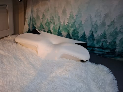 Avis d'un client sur le coussin d'alignement cervical Cellsius, posé sur une couverture blanche moelleuse.