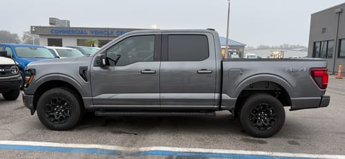 Customer's gray F-150 truck in a parking lot before installing the Upper Control Arms and 3" Front Leveling Lift Kit.