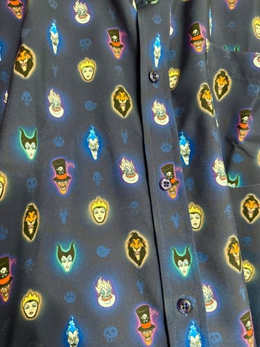 Close-up of a customer's 'Vile Luminescence' shirt, showing the glowing Disney villains pattern on the dark blue fabric.
