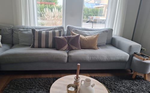 Recensent toont het HKliving Velvet Sierkussen gecombineerd met andere kussens op een bank.