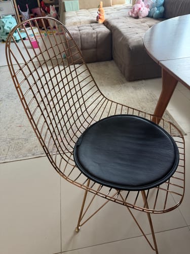 Customer's rose gold Wire Dining Chair with a black leather cushion in a living room.