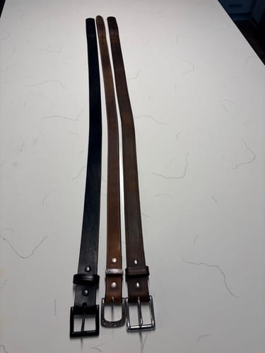 Reviewer's three leather belts, including the Wyoming Bison, displayed side-by-side on a countertop.