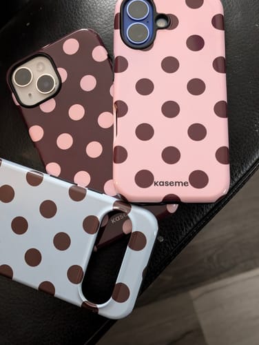 Reviewer's three polka-dotted phone cases in various colors, featuring the Couture Blue design.