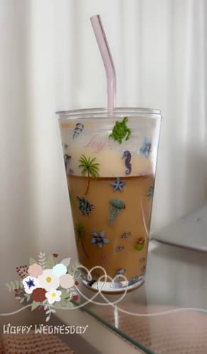 Reviewer's Maldives Tumbler Glass holding iced coffee with a pink straw, showcasing the sea life print.