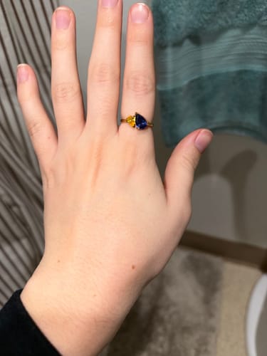 Customer wearing the Leesha Birthstone Ring with blue and yellow stones on their hand.