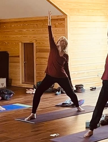 Reviewer wearing the black Piper Pocket Leggings while holding a yoga pose in a studio.
