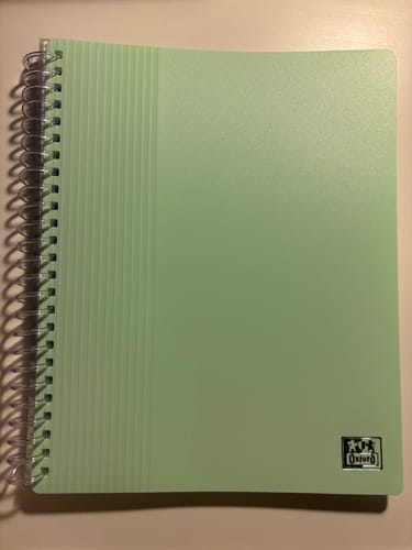 Un client montre son protège-documents OXFORD A5. La couverture vert pastel est fermée.
