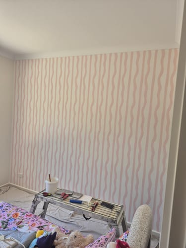 Customer's bedroom wall featuring the new Mixed Stripe Wallpaper in Blush.