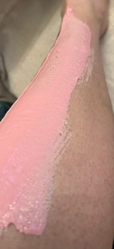Customer's leg with a thick layer of pink hard wax applied before removal, as mentioned in the review.