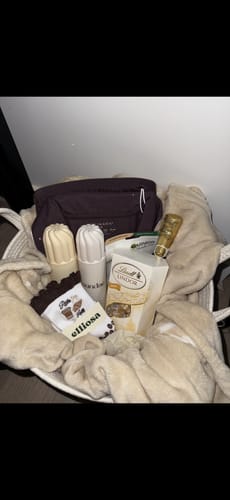 Customer's 'Pilates & Lattes' socks displayed in a cozy gift basket for a Secret Santa present.