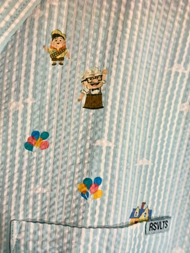 Close-up of customer's 'Going Up!' seersucker shirt showing the striped fabric with Carl, Russell, and balloons.