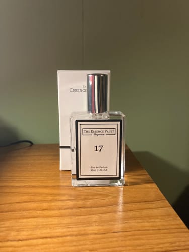 Customer's bottle of Inspired by Daisy - 17 perfume and its white box sitting on a wooden table.