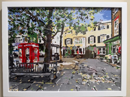 Reviewer's completed paint-by-numbers artwork of a Richmond street scene with a pub and red phone booth, framed on a wall.