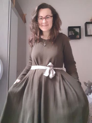 Cliente portant la Robe Louisa kaki, ceinturée à la taille et montrant sa jupe ample.