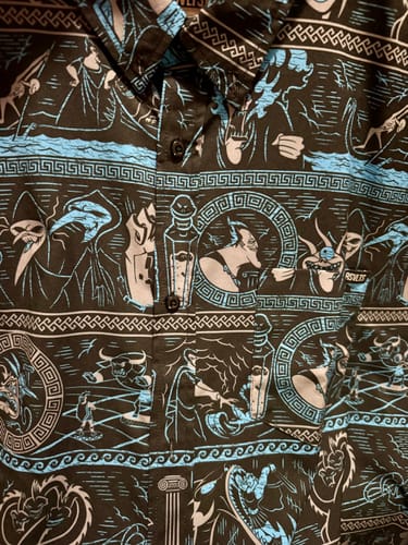 Close-up of a customer's 'Hades Gonna Hate' shirt, showing the black fabric with a blue and grey graphic Hercules pattern.