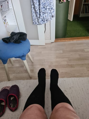 Recensent som bär de bekväma, svarta Diasocks Komfortstrumpor hemma.