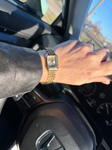 Customer wearing the two-tone CLAIRE DE MAINS watch on their wrist while driving.