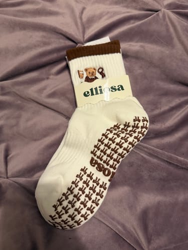 Customer's white Beary Latte socks with a brown cuff and sole featuring bear-shaped grips.