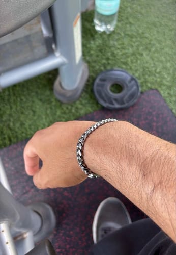 Cliente mostrando su Pulsera Cuban de 8mm en la muñeca en un entorno de gimnasio.