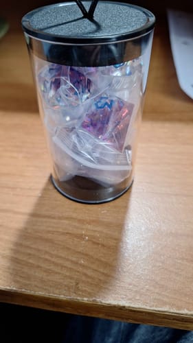 Customer's Conjure Elemental dice set in individual plastic bags inside the clear storage tube.