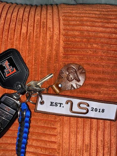 Customer's Western Jet Tag attached to a set of keys on an orange textured surface.