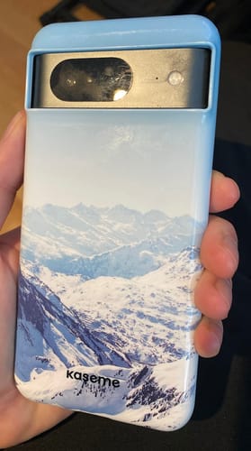 Reviewer holding the Massif phone case with a snowy mountain design, showing the fit around the camera.