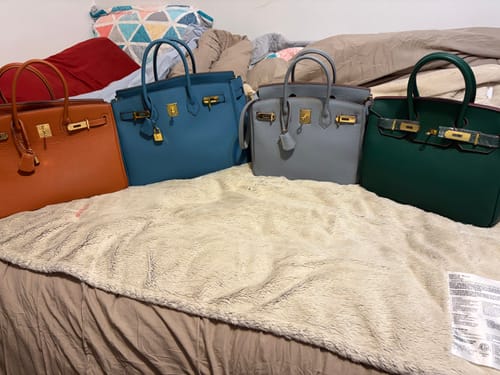 Customer's four LALUVA Warkin Leather Bags in orange, blue, grey, and green lined up on a bed.