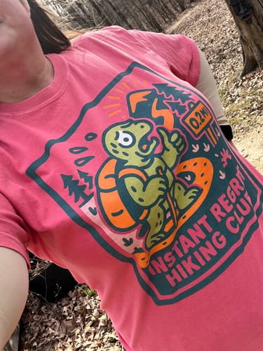 Customer wearing the pink graphic Instant Regret T-Shirt outdoors.