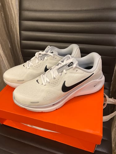 Customer's white Nike Structure 26 Road Running Shoes displayed on top of the orange Nike shoebox.
