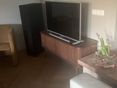 Recensent toont het donkerbruine Barbier dressoir in de woonkamer met een tv erop.