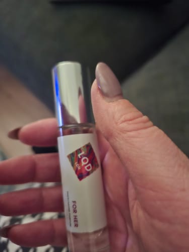 Close-up of a reviewer holding the For Her Pheromone Perfume bottle.