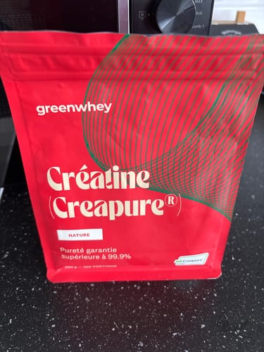 Photo d'un client montrant le sachet rouge de Créatine Creapure® de la marque greenwhey.