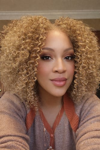 Reviewer wearing the blonde Kinky Soft Edges wig, showing its full texture and defined kinky curls.