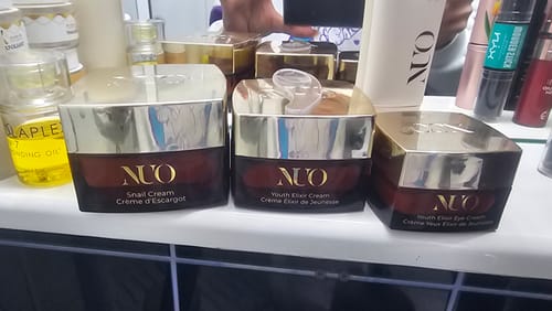 Reviewer's Youth Elixir Eye Cream on a bathroom counter next to other products from the Nuo skincare line.