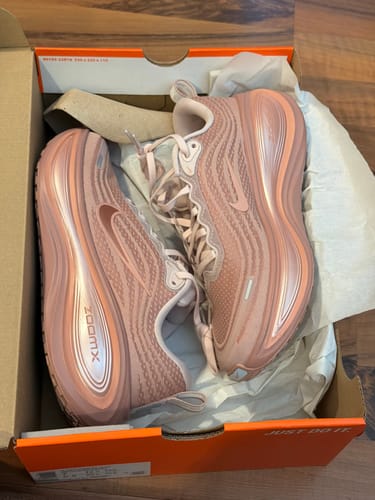 Customer's new pink Nike Vomero Plus shoes sitting in the open shoebox.