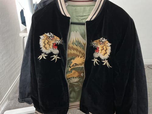 Customer's black reversible Souvenir Jacket, unzipped to show the tiger embroidery and the falcon design on the reverse side.