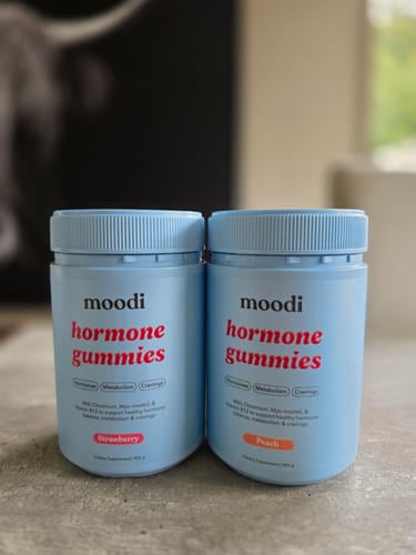 Customer's two light blue bottles of Original Hormone Gummies, strawberry and peach flavors, side by side.